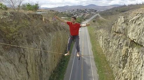 نوجوان کا پہاڑوں کے  درمیان رسی پر چلنے کا مظاہرہ