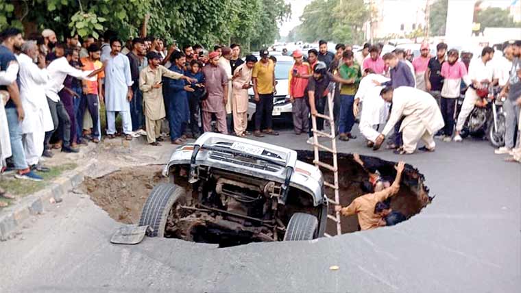 جوہرٹاؤن:شاہراہ میں پھر شگاف،گاڑی،موٹرسائیکل گر گئے